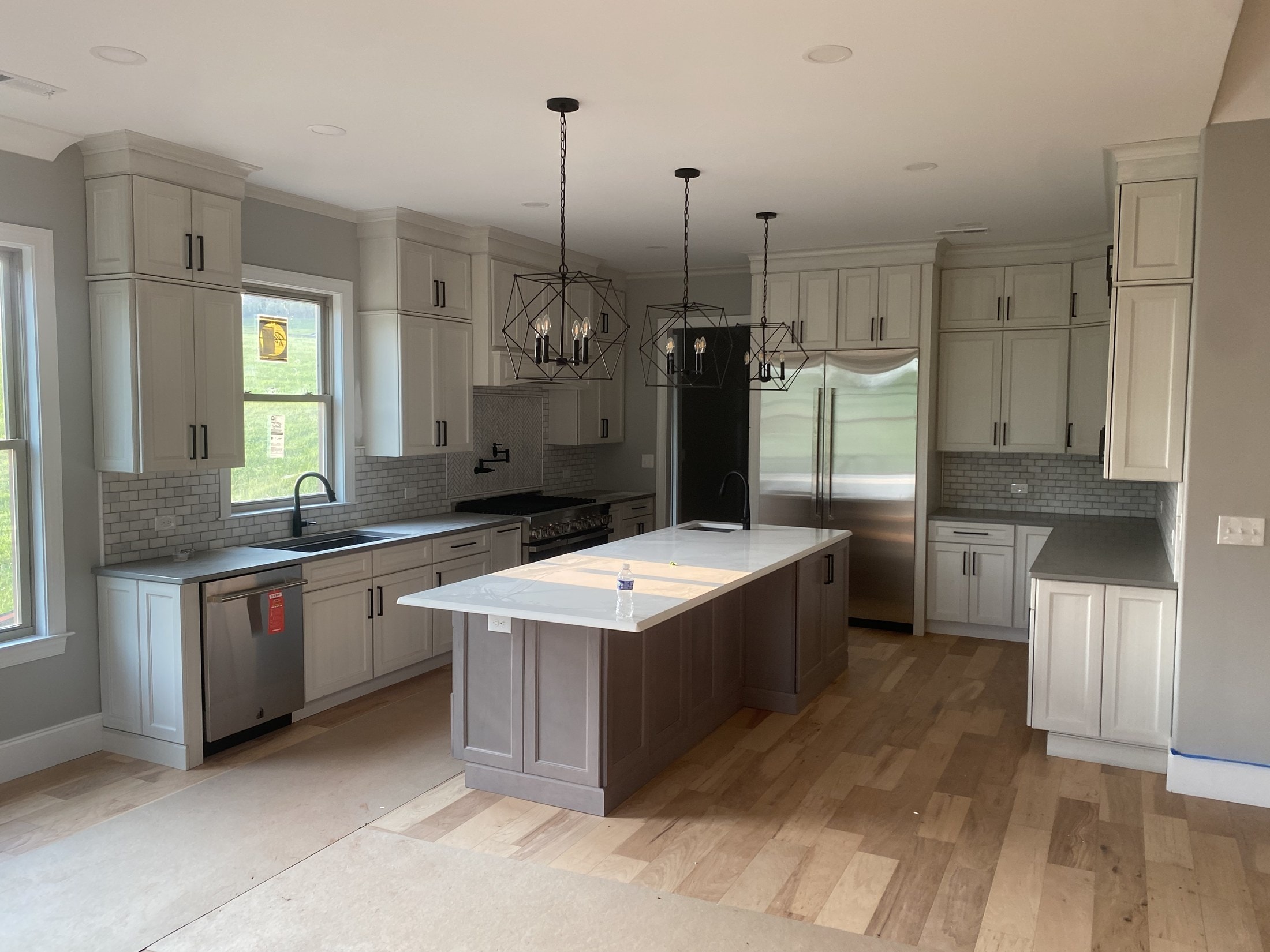 White shaker kitchen cabinets installed with crown and light rail